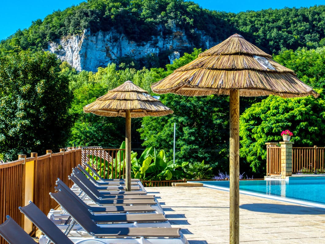 Transats au bord de la piscine du camping près de Sarlat